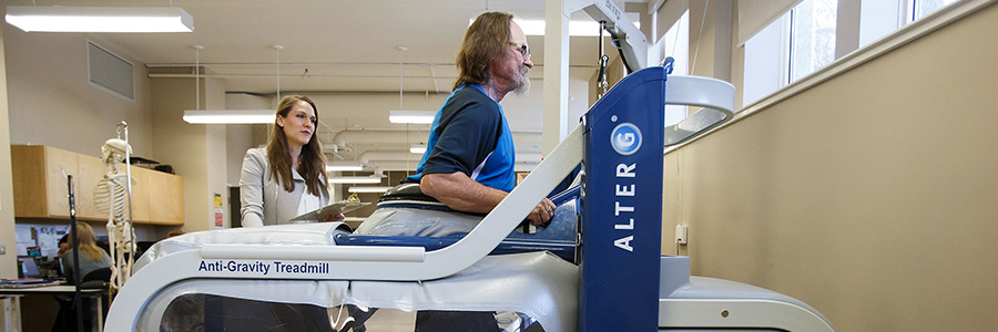 Man on treadmill with student observing