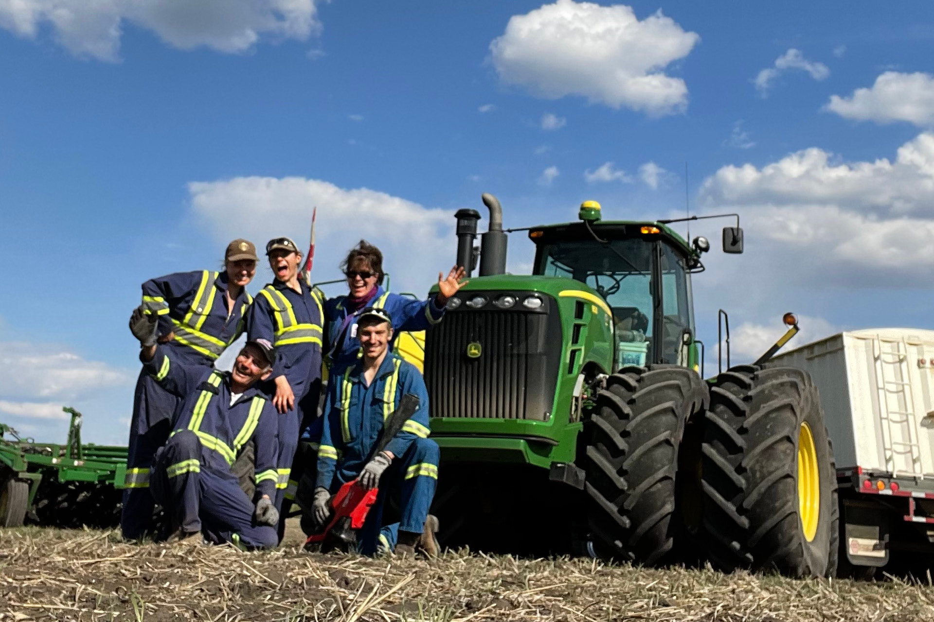 Alyson and family pose in front of a tractor on their family farm.